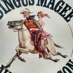 May include: A vintage illustration of a cowboy riding a white horse with a woman sitting behind him. The illustration is titled "The Ballad of Angus Magee" and signed "David Markson".