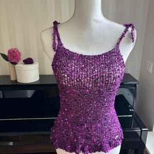 Può includere: Top a spalline sottili di colore viola con paillettes. Il top è realizzato in tessuto lavorato a uncinetto e ha un orlo arricciato.