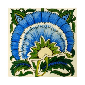 May include: A blue and green floral tile with a stylized flower design. The flower has a white center and blue petals with green leaves.