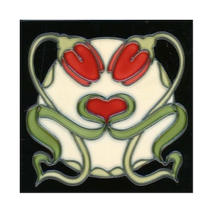 May include: A white ceramic tile with a stylized floral design. The design features red and green leaves and a heart shape in the center.
