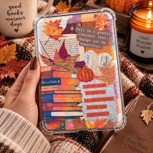 May include: A clear protective phone case featuring a collage of autumn-themed imagery, including orange maple leaves, a stack of books, and a small pumpkin. The design includes text that reads: fall is a gentle reminder that change can be beautiful and IM SO GLAD I LIVE IN A WORLD WHERE THERE ARE OCTOBERS.