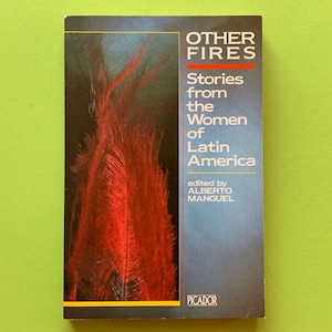Può includere: Copertina di un libro con il titolo "OTHER FIRES" in lettere maiuscole bianche sopra una linea rossa. La copertina presenta uno sfondo scuro con un disegno rosso a forma di fiamma. È visibile anche il testo "Stories from the Women of Latin America".