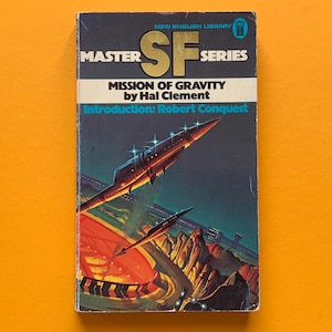 May include: Vintage paperback book cover for "Mission of Gravity" by Hal Clement. The cover features a dark blue background with a futuristic spaceship design and the text "MASTER SF SERIES". The book is set against an orange background.