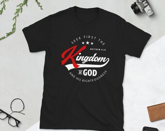 Peut inclure: T-shirt noir avec un motif graphique blanc qui dit "Seek First The Kingdom of God and His Righteousness" avec un "Kingdom" rouge et blanc dans une police de caractères de style vintage. Matthieu 6:33 est également inclus dans le design.