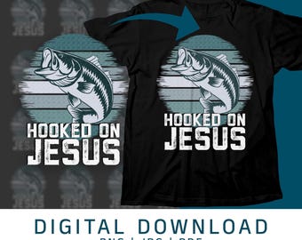 Könnte beinhalten: Ein schwarzes T-Shirt mit einem Grafikdruck eines Fisches und dem Text "Hooked on Jesus". Die Grafik ist auf einem blau-weiß gestreiften Hintergrund.