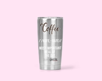 May include: A silver stainless steel tumbler with a black and white design that reads "Coffee /'/KOFE,- KAFE// MOST IMPORTANT MEAL OF THE DAY. SIMPLYCRYSTAL"