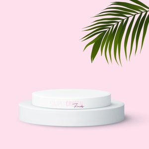 May include: Two white round platforms on a pink background with a green palm leaf in the top right corner. The top platform has the text "SIMPLY CRYSTAL Finds" in pink.
