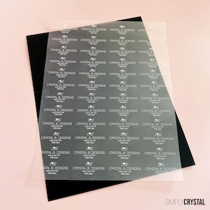 以下が含まれることがあります： 透明なラベルのシートで、"CRYSTAL B. DESIGNS MADE IN NEW YORK 100% Cotton"というテキストがグリッドパターンで繰り返されています。