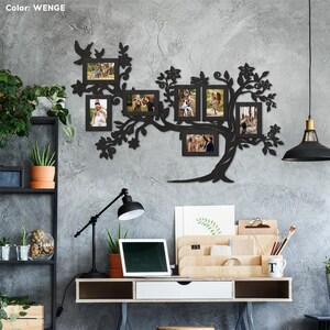 May include: Black metal wall art in the shape of a tree with branches holding eight photo frames. The frames are empty and ready for pictures. The wall art is mounted on a gray wall. The word "WENGE" is visible in the top left corner of the image.