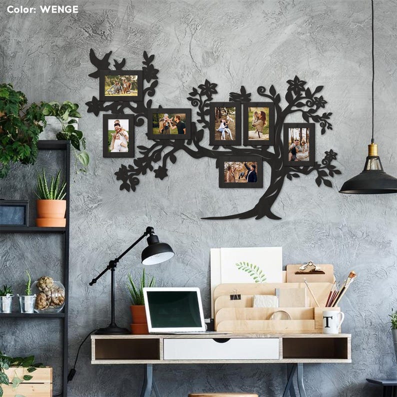 May include: Black metal wall art in the shape of a tree with branches holding eight photo frames. The frames are empty and ready for pictures. The wall art is mounted on a gray wall. The word "WENGE" is visible in the top left corner of the image.