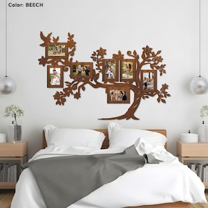 May include: A wooden wall decor in the shape of a tree with eight photo frames. The frames are arranged in a branch-like pattern. The tree is painted in a brown color. The word "BEACH" is written in white text on a white background.