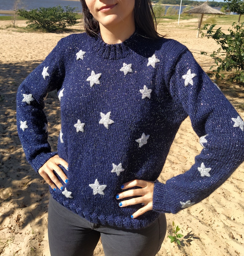 May include: A navy blue sweater with silver glitter and white star accents.