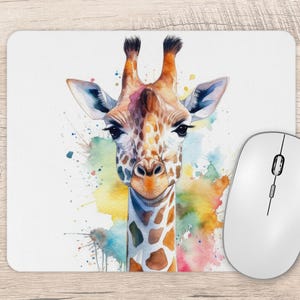 May include: A white mouse mat with a watercolour illustration of a giraffe's face. The giraffe has brown and orange spots, with a blue and yellow watercolour background. A white computer mouse is next to the mouse mat.