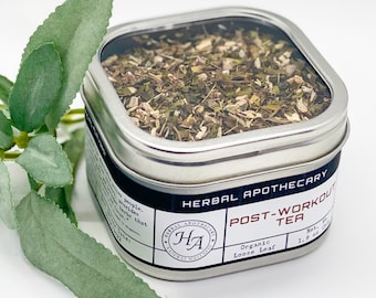 May include: A silver tin with a clear lid filled with loose leaf herbal tea. The label reads "Herbal Apothecary Post-Workout Tea Organic Loose Leaf".
