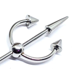 May include: A silver-colored industrial barbell body piercing with a central spike and curved ends, each tipped with a conical point. The design features a ball in the center of the barbell.