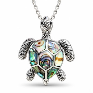 May include: A silver-toned turtle pendant necklace featuring a shell inlaid with iridescent abalone shell segments. The turtle has a textured, metallic head and flippers with dark eyes, suspended from a delicate silver-toned metal chain link.