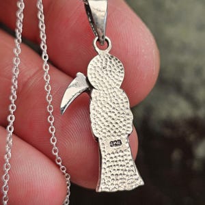 Pu&ograve; includere: Collana con ciondolo in argento che presenta una rappresentazione dettagliata della Morte che tiene una falce. Il retro del ciondolo &egrave; timbrato con "925", a indicare l'argento sterling.