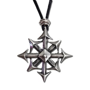 Op de afbeelding: Een zilveren ketting met een stervormige hanger. De hanger heeft een centrale diamantvorm en acht punten. De ketting is aan een zwart koord.