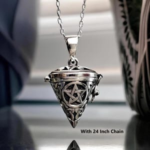May include: A silver-toned metal pendant shaped like an inverted triangle, featuring a central pentagram symbol surrounded by intricate knotwork patterns. The pendant hangs from a silver-toned chain and includes the text With 24 Inch Chain.