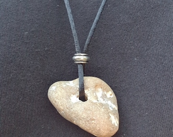 May include: A brown stone with a hole drilled through it is attached to a black cord necklace. The cord has a silver bead at the top.