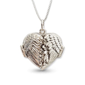 May include: A silver heart-shaped pendant with an angel wings design. The pendant hangs from a fine silver chain. The wings are intricately detailed, giving a textured look. The locket is a piece of jewellery.