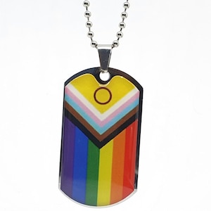 May include: A silver chain necklace with a dog tag pendant featuring a rainbow pride flag with a black and brown chevron and a yellow circle in the centre.