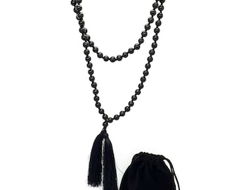 May include: A black beaded necklace with a tassel, and a black velvet drawstring pouch.