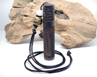 May include: A dark brown wooden cylinder pendant with intricate carvings and Chinese characters. The pendant is attached to a black cord with a white bead and a gold-colored bead with a decorative design.