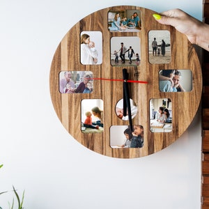 May include: A round wooden clock with a red second hand and black hour and minute hands. The clock face is divided into 12 sections, each containing a small photo of a family.