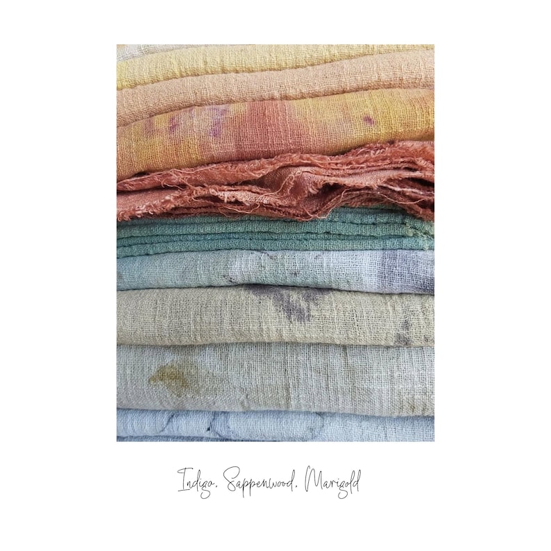 May include: A stack of colorful, textured fabric in shades of yellow, orange, green, and blue. The fabric appears to be hand-dyed, with visible variations in color and texture. The text "Indigo. Sappperwood. Marigold" is written in cursive at the bottom.