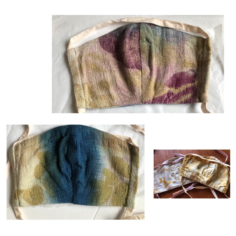 May include: Face masks in various colors and patterns. One mask has a blue and green tie-dye effect, another has a purple and green pattern, and the third has a yellow and white pattern. All masks have cream-colored ties.
