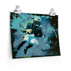 Puede incluir: Un jugador de fútbol americano con un uniforme azul y verde corre con el balón, rodeado de un fondo abstracto azul y verde.