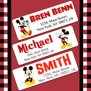 May include: Three white rectangular labels with Mickey Mouse cartoon images and red text. The labels have names, addresses, and the text "1234, Main Street, New York, NY 10021, US".