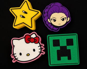 May include: Four colorful cartoon character patches. A yellow star with eyes, a purple-haired anime-style character, a white Hello Kitty with a red bow, and a green square with a black pixelated face.