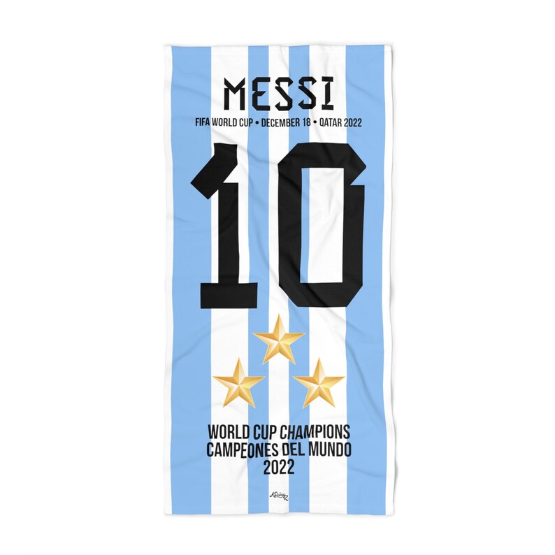 Puede incluir: Una toalla de playa a rayas azul y blanca con el n&uacute;mero "10" en negro y el texto "MESSI FIFA WORLD CUP DECEMBER 18 QATAR 2022 WORLD CUP CHAMPIONS CAMPEONES DEL MUNDO 2022" en negro. Hay tres estrellas doradas en la toalla.