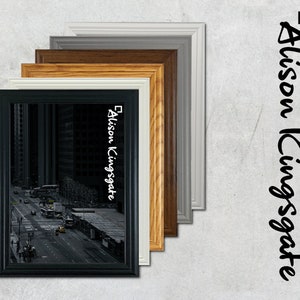 Puede incluir: Un marco de fotos negro con una foto de ciudad en su interior. El marco está rodeado por otros cinco marcos de diferentes colores, incluyendo blanco, gris y marrón.