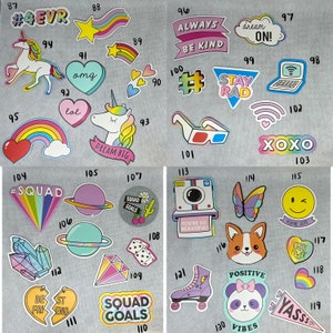May include: A colorful set of 120 iron-on patches with various designs and phrases. The patches feature a variety of themes, including friendship, positivity, and squad goals. Some of the patches include text such as "#Squad", "Squad Goals", "Stay Rad", "Dream On", "Always Be Kind", "XOXO", "You're So Beautiful", "You're Cute", "Girl Power", "Positive Vibes", and "Yass".