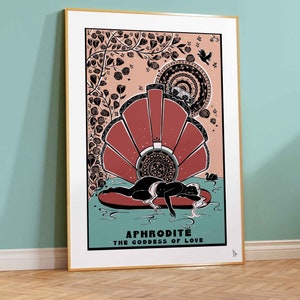 May include: Aphrodite, the Goddess of Love, is depicted in a black and white illustration with a red and white shell behind her. The illustration is surrounded by a floral design with a pink background.