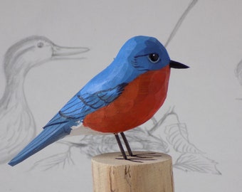 May include: Hand-carved wooden bluebird figurine with a red breast, perched on a wooden base. The base is inscribed with the word "Halibut."