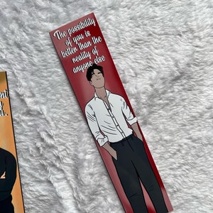 May include: A bookmark with a red background. It features an illustration of a person in a white shirt and black trousers. The text "The possibility of you is better than the reality of anyone else" is printed at the top.