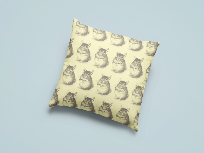 May include: Square throw pillow with a repeating pattern of vintage-style chinchilla illustrations in shades of gray on a pale yellow background. The pillow is a decorative item, likely for a living room or bedroom.