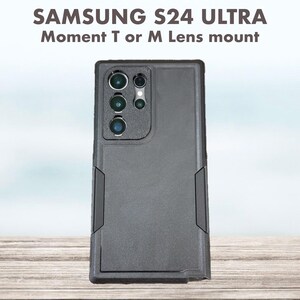 Pu&ograve; includere: Una custodia nera per telefono Samsung S24 Ultra con supporto per obiettivo Moment T o M. La custodia ha un retro strutturato e un telaio rinforzato. La parte superiore presenta ritagli per gli obiettivi della fotocamera del telefono.