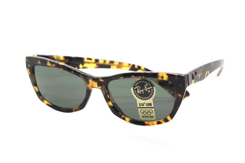 May include: Tortoise shell Ray-Ban sunglasses with green lenses and a gold sticker that says "G-15 Lens" and has the Olympic rings logo.