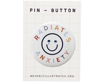 Könnte beinhalten: Ein weißer Knopf mit einem schwarzen Umriss eines Smiley-Gesichts mit blauen Tränen. Der Text "RADIATE ANXIETY" ist in einem Regenbogen von Farben um das Smiley-Gesicht geschrieben.