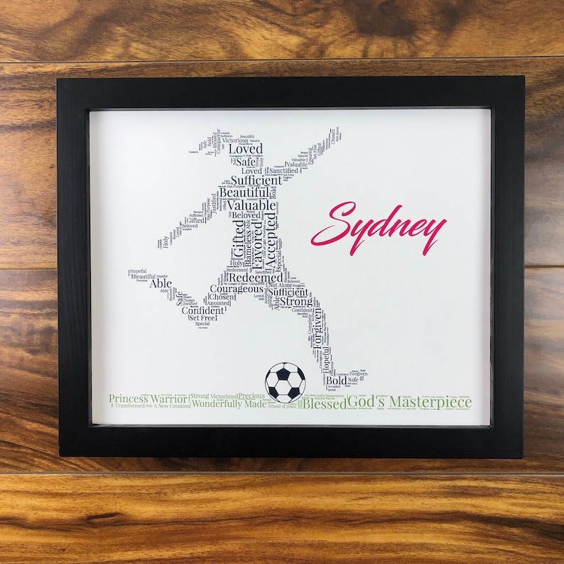 word art with words in the shape of a female soccer player and colored black. Ground below is green. Hot pink name printed beside player. The words in the print remind her of identity in Christ - God’s masterpiece, valuable, loved, forgiven, etc