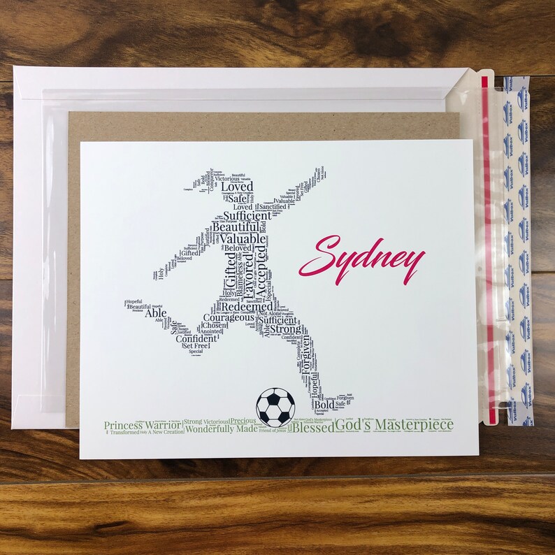 word art with words in the shape of a female soccer player and colored black. Ground below is green. Hot pink name printed beside player. The words in the print remind her of identity in Christ - God’s masterpiece, valuable, loved, forgiven, etc
