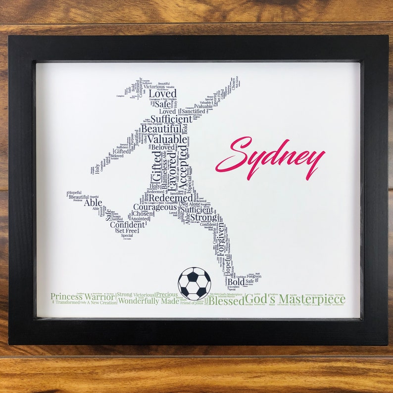 word art with words in the shape of a female soccer player and colored black. Ground below is green. Hot pink name printed beside player. The words in the print remind her of identity in Christ - God’s masterpiece, valuable, loved, forgiven, etc