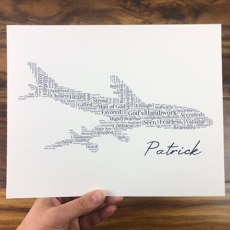 Word art with words in the shape of an airplane in gray color. Black name printed below airplane. The words in the print remind him of identity in Christ - God’s handiwork, valuable, loved, forgiven, etc.
