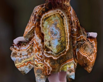 Puede incluir: Un kimono de color marrón, naranja y amarillo con un gran patrón circular. El kimono está hecho de una tela suave y fluida y tiene un corte holgado.