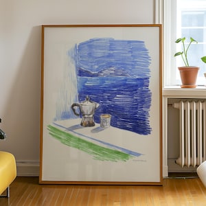 May include: A framed artwork featuring a still life scene with a coffee pot, cup, and a view of the sea. The artwork is rendered in blue, green, and brown tones, with a wooden frame. The artwork is leaning against a white wall.